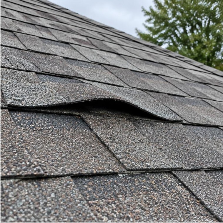 Blue tarp over a storm-damaged roof